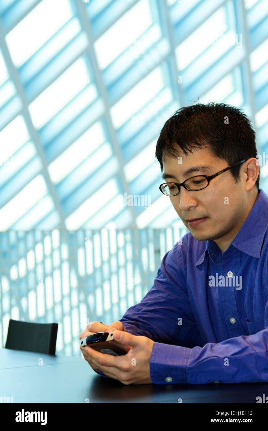 A businessman working on his PDA at the office Stock Photo Alamy