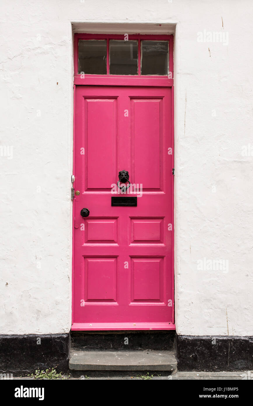 Bright pink Victorian British front door on a white empty wall Stock Photo
