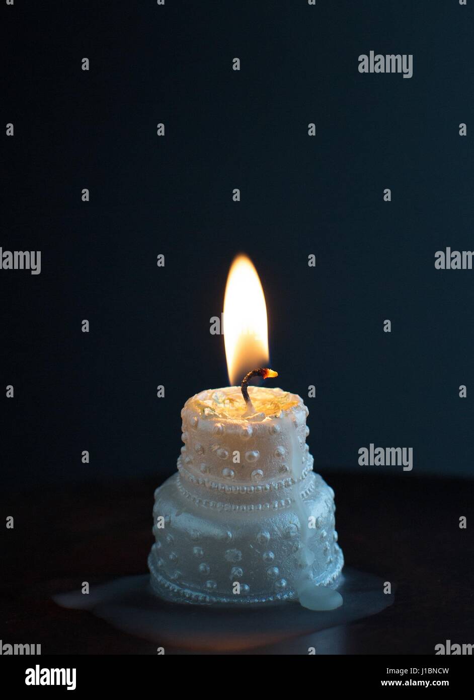A burning, melting wedding cake candle Stock Photo Alamy