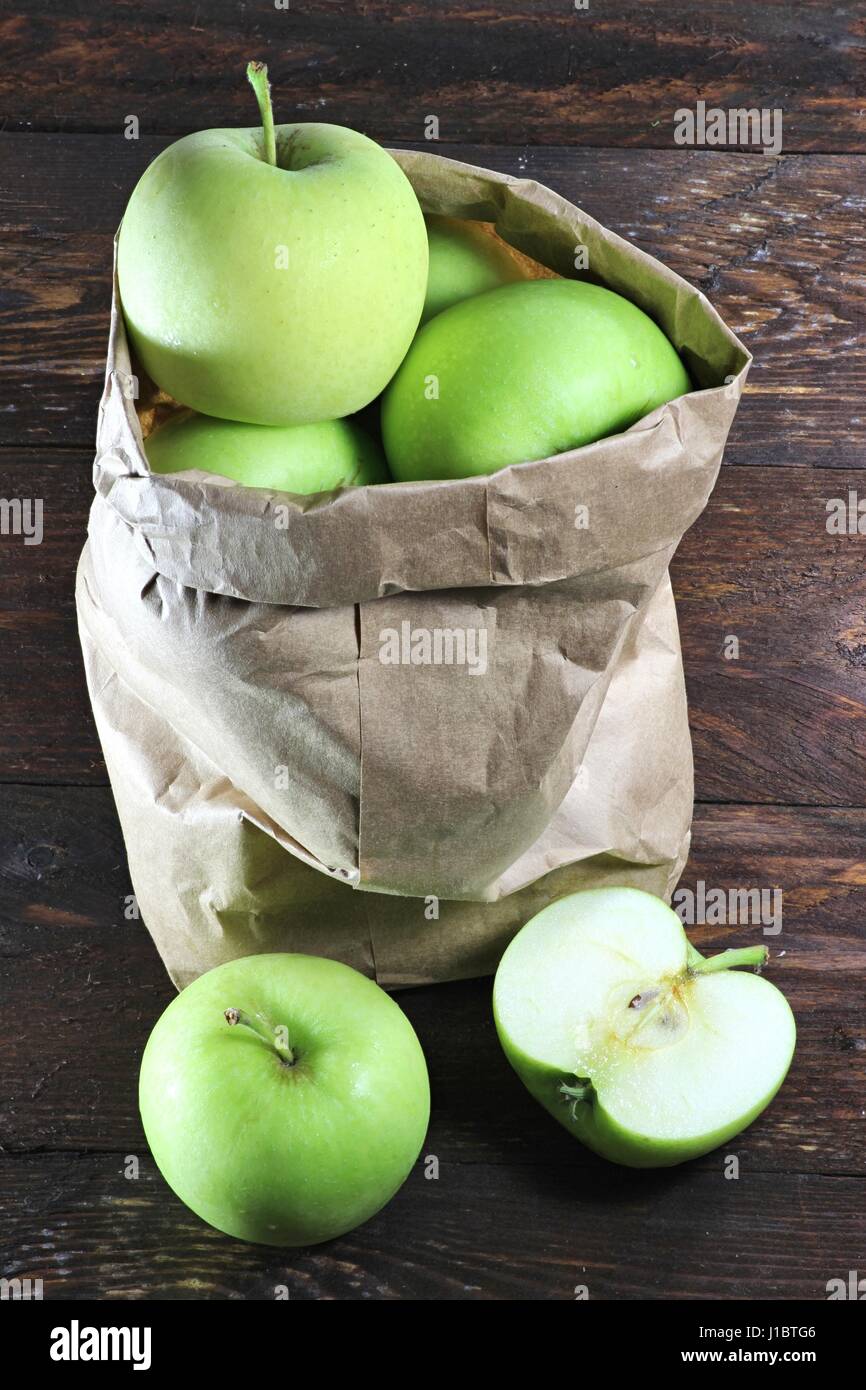 apples (variety Delcorf) in a paper bag on wooden background Stock Photo