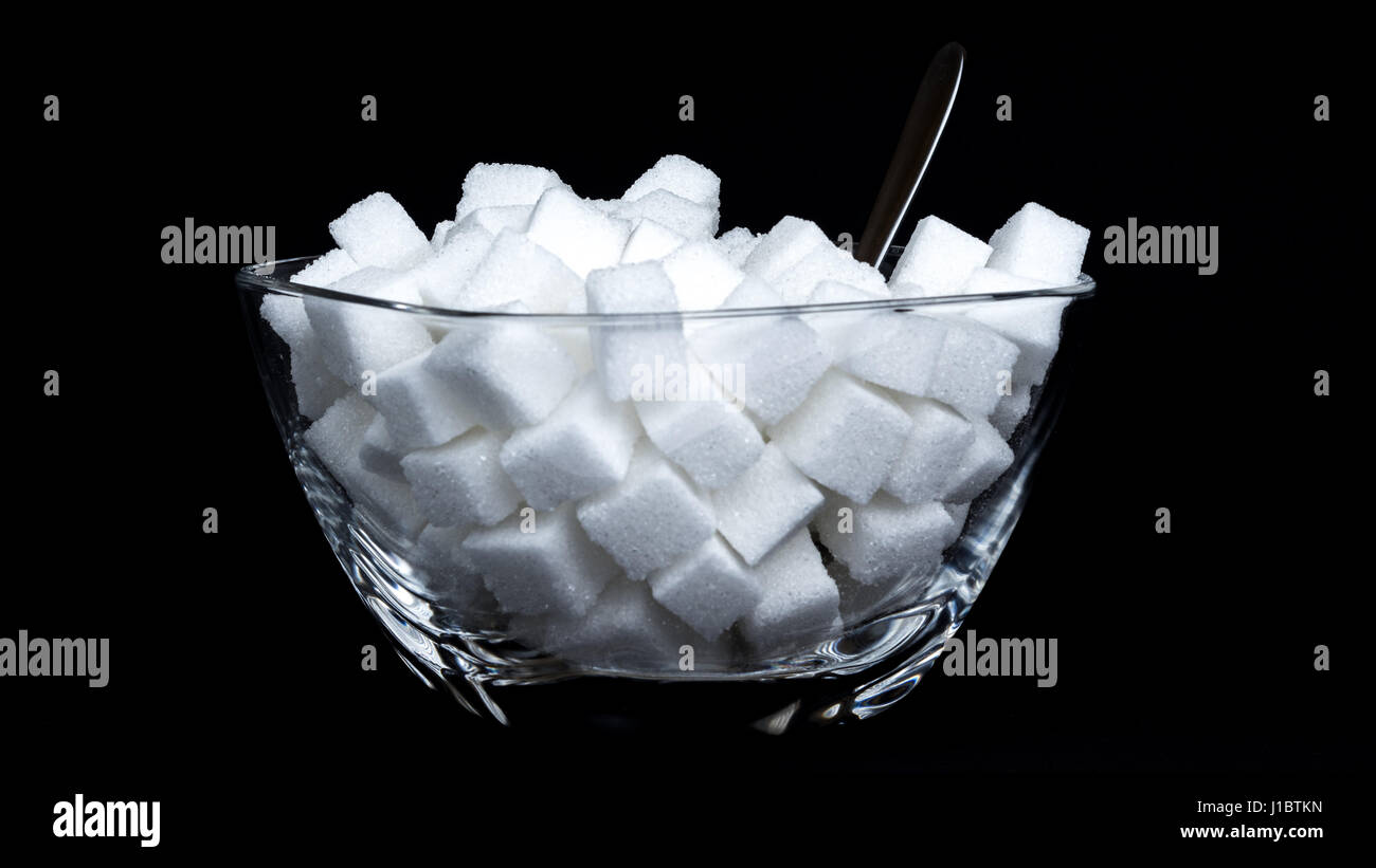 Glass bowl full of sugar cubes - concept of consuming too much sugar Stock Photo