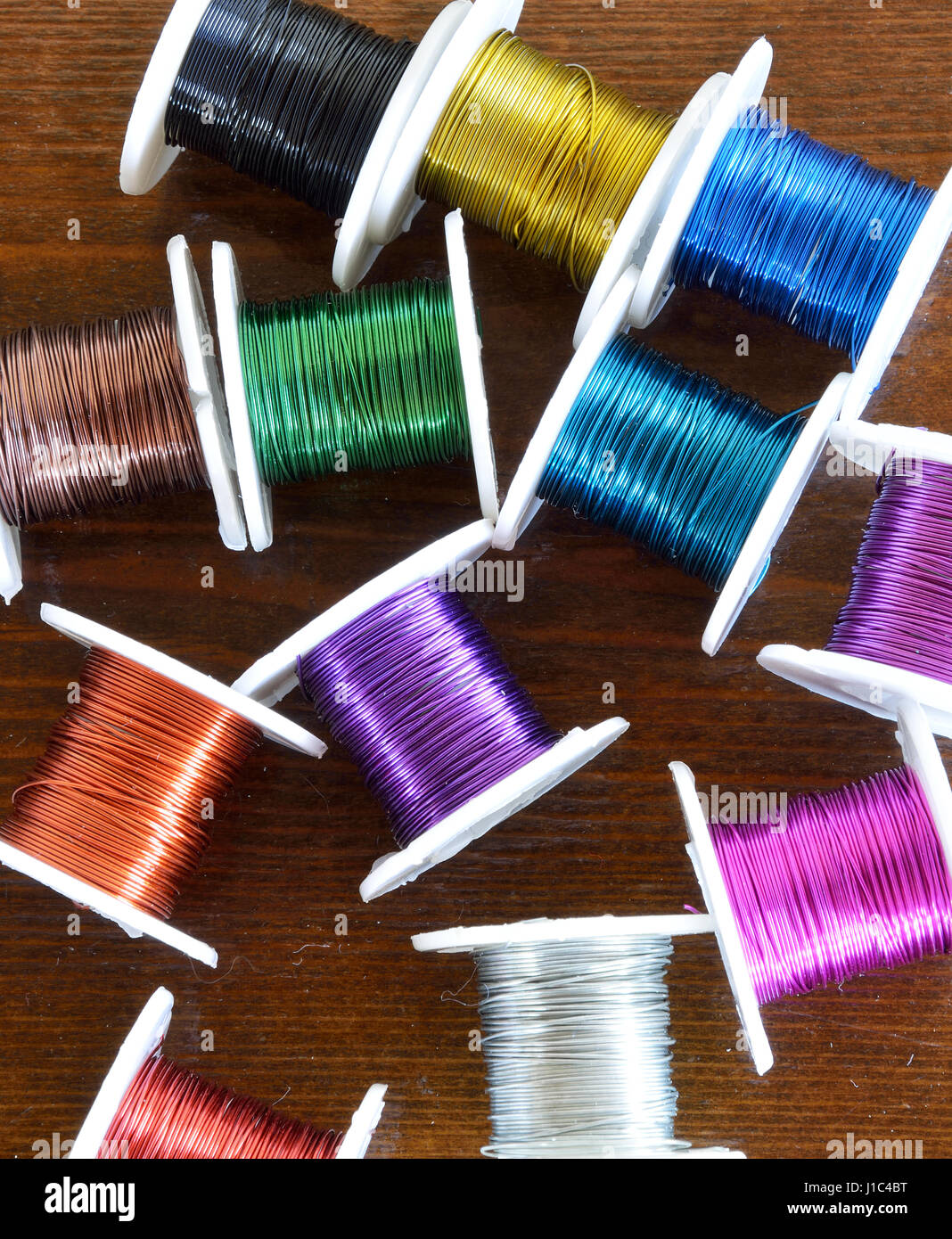 Color thin wire crafts on wooden surface Stock Photo - Alamy