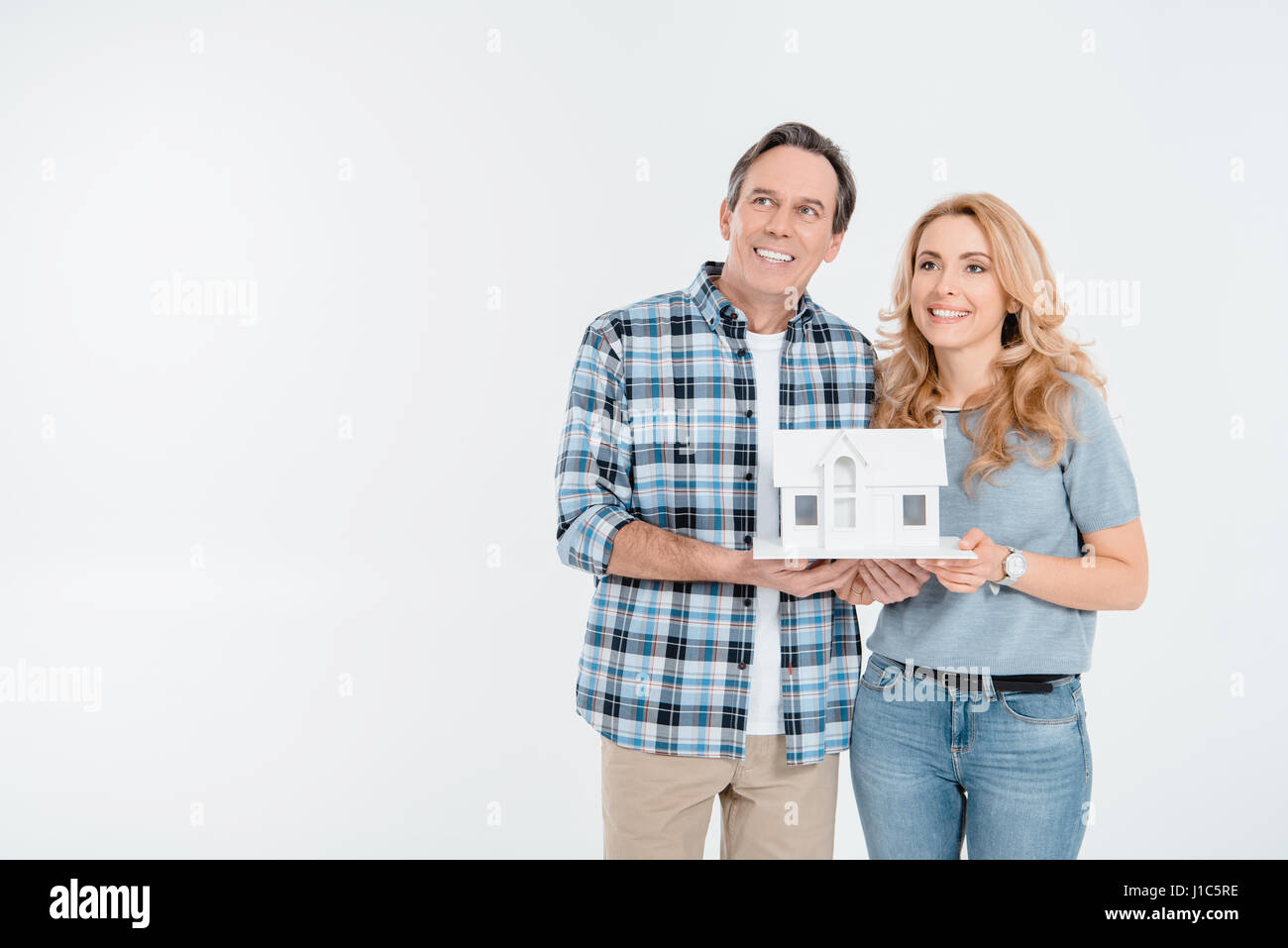 Front view of happy couple holding house model on white Stock Photo - Alamy