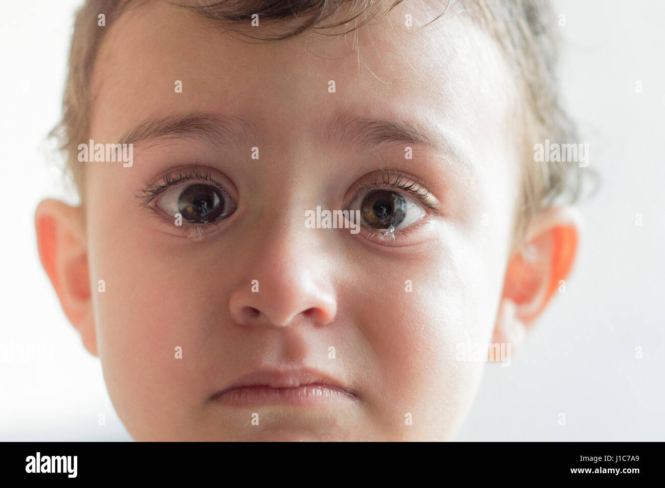 Face of Hispanic boy crying Stock Photo