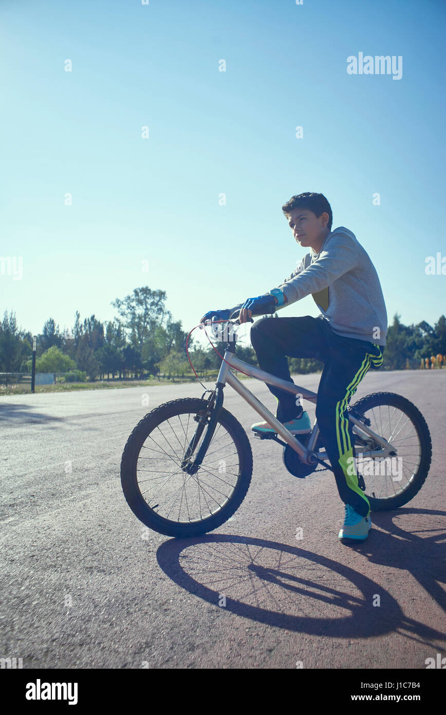 Serious Hispanic boy on bicycle Stock Photo