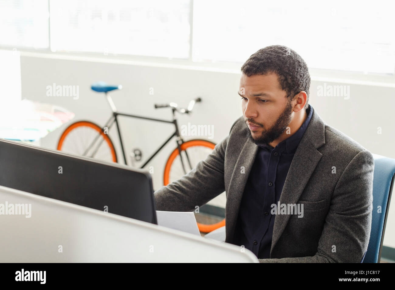 Mixed Race man using computer in office Stock Photo