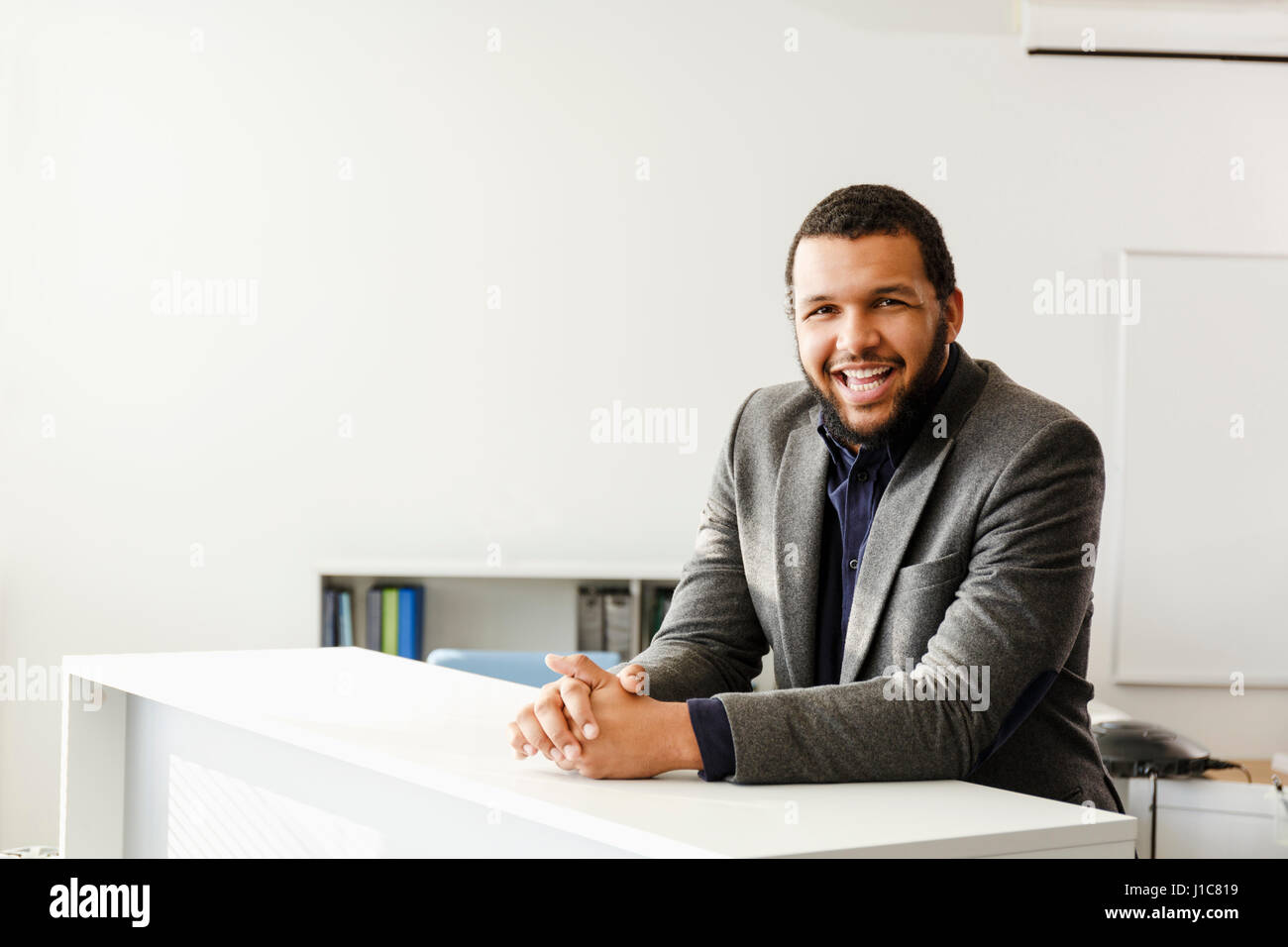 Mixed Race man smiling in office Stock Photo