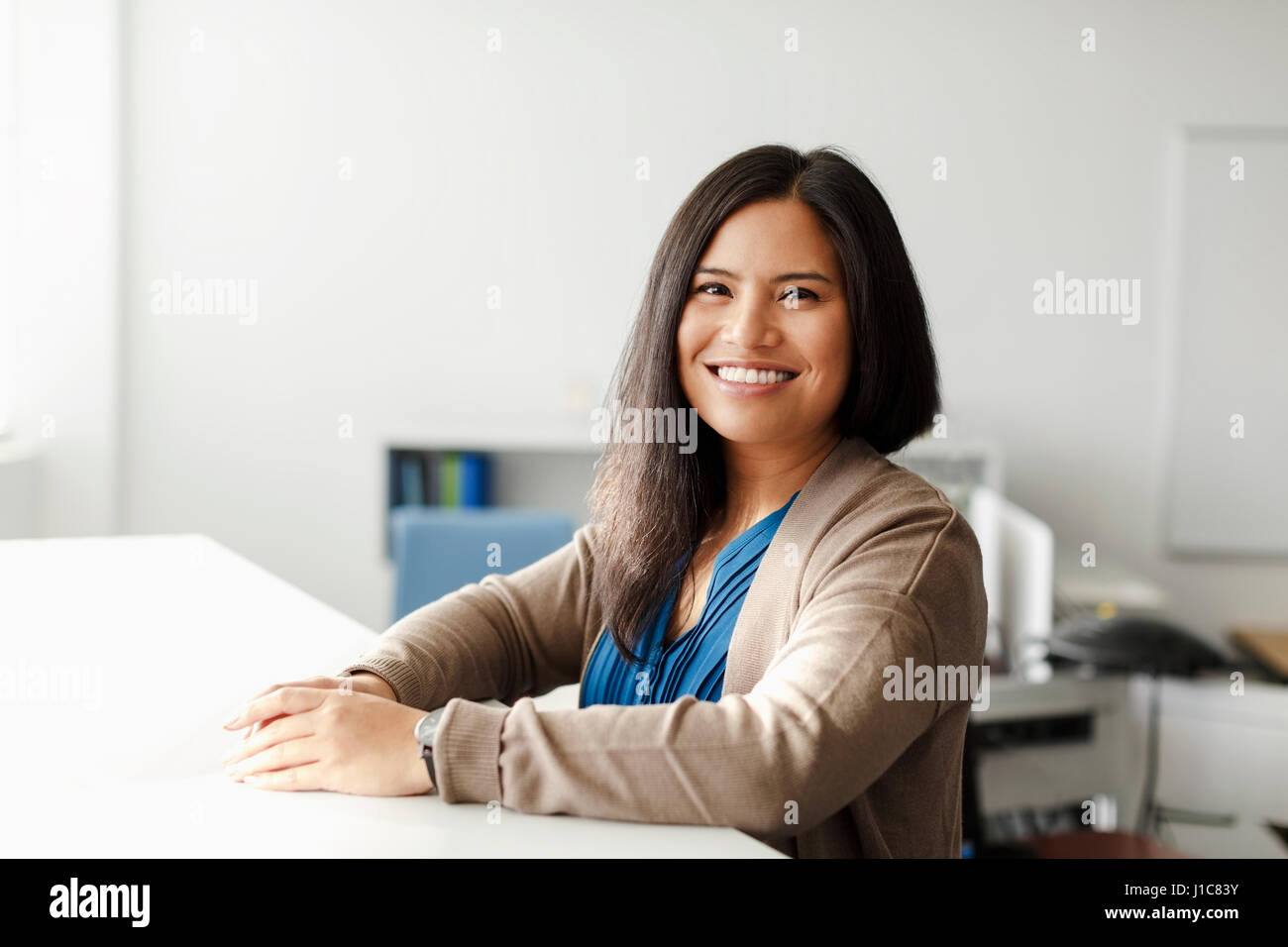 Smiling Pacific Islander woman in office Stock Photo