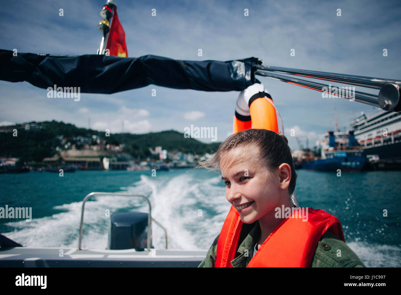 Caucasian woman wearing life-jacket in speedboat Stock Photo
