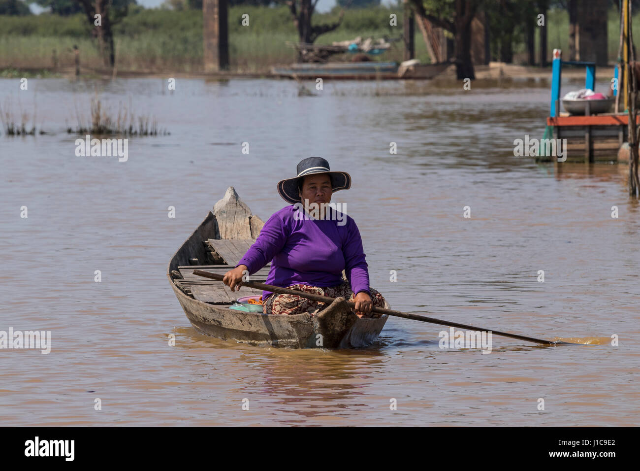 Woman sailing in boat near the Floating housesalong the Sangker river, Prek Toal, Cambodia Stock Photo