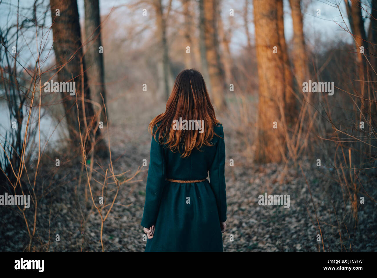 Caucasian woman standing near trees and river Stock Photo - Alamy