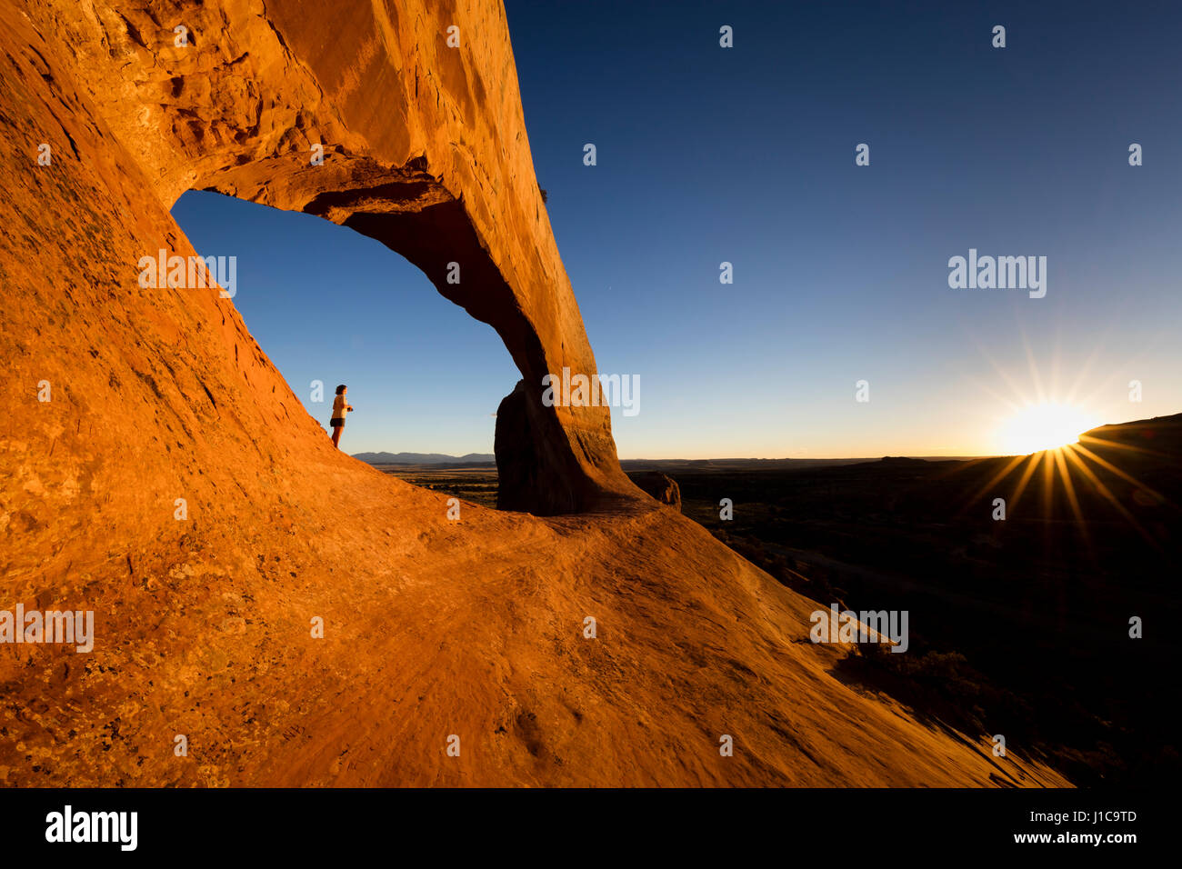Stephanie Summerfield standing below Wilson Arch near Moab, Utah. Stock Photo