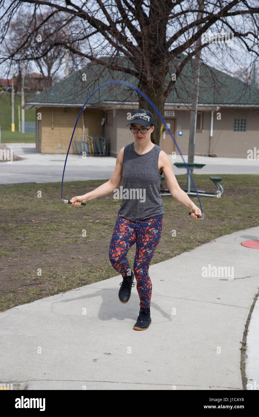 WOMAN SKIPPING ROPE IN PARK Stock Photo - Alamy