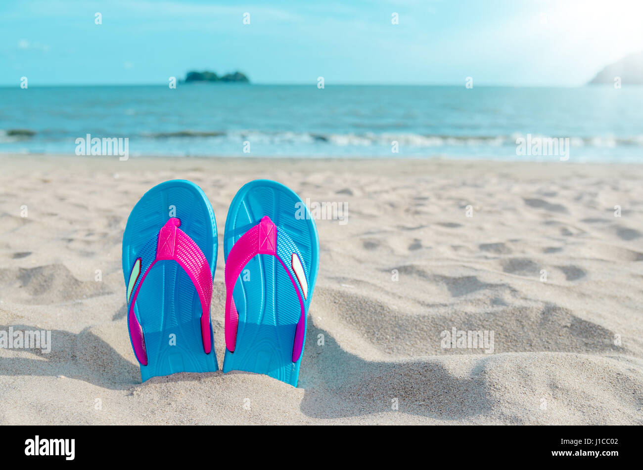 Colorful flip flops on beach against sunny sky. Summer vacation concept ...