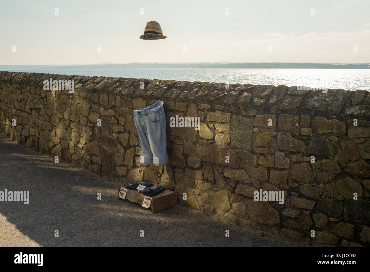 An invisible man installation at St Ives, Cornwall where tourists and locals can take a selife with the invisible man for a donation of 50p. Stock Photo