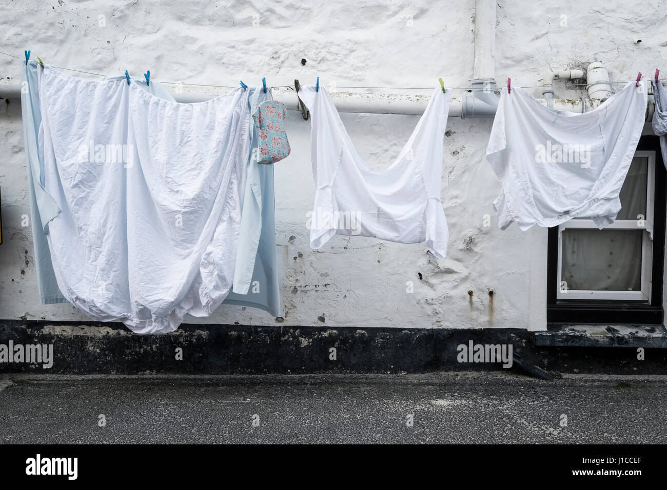 Washing out on a line against a white washed house in the traditional cornish coastal town of St Ives Stock Photo