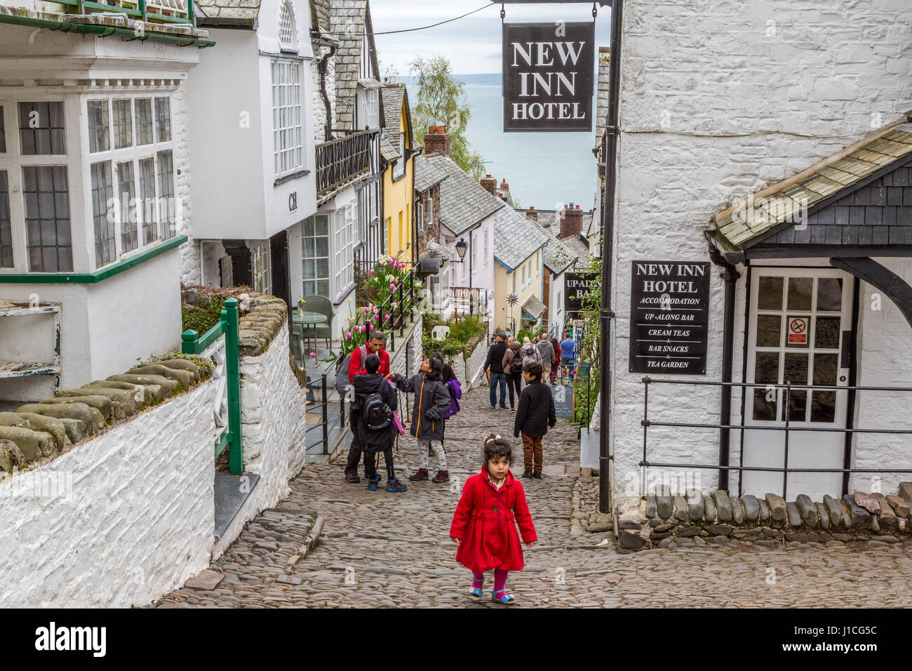 Clovelly,North Devon,England,UK. Visitors and tourists enjoy the steep and picturesque cottages, cobbled high street of this secluded village in Devon Stock Photo