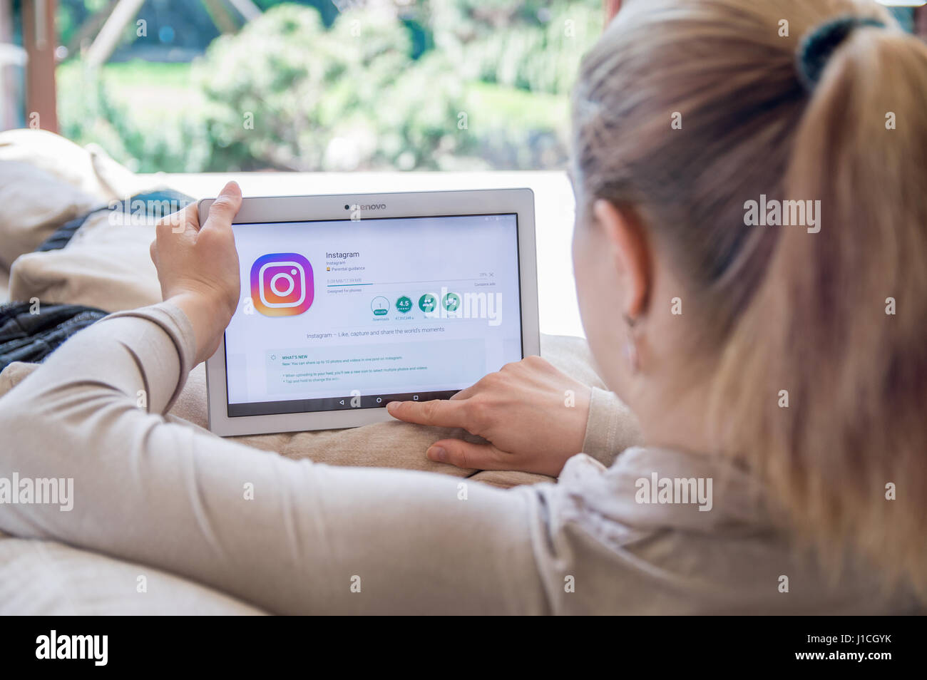 WROCLAW, POLAND- APRIL 10th, 2017:  Woman is installing Instagram application on Lenovo tablet. Instagram is a mobile photo-sharing application Stock Photo