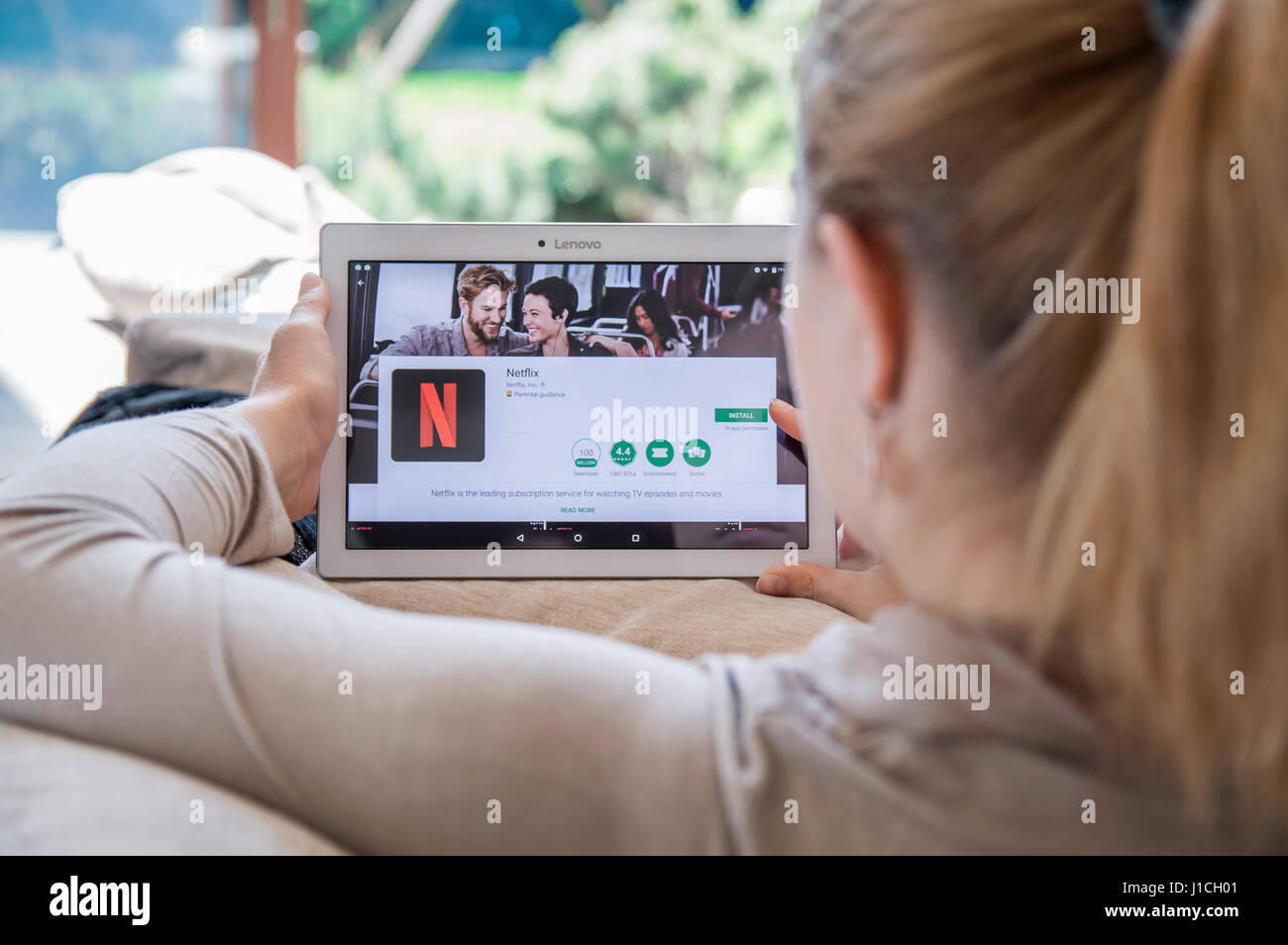 WROCLAW, POLAND- APRIL 10th, 2017:  Woman is installing Netflix application on Lenovo tablet. Netflix is an American entertainment company Stock Photo