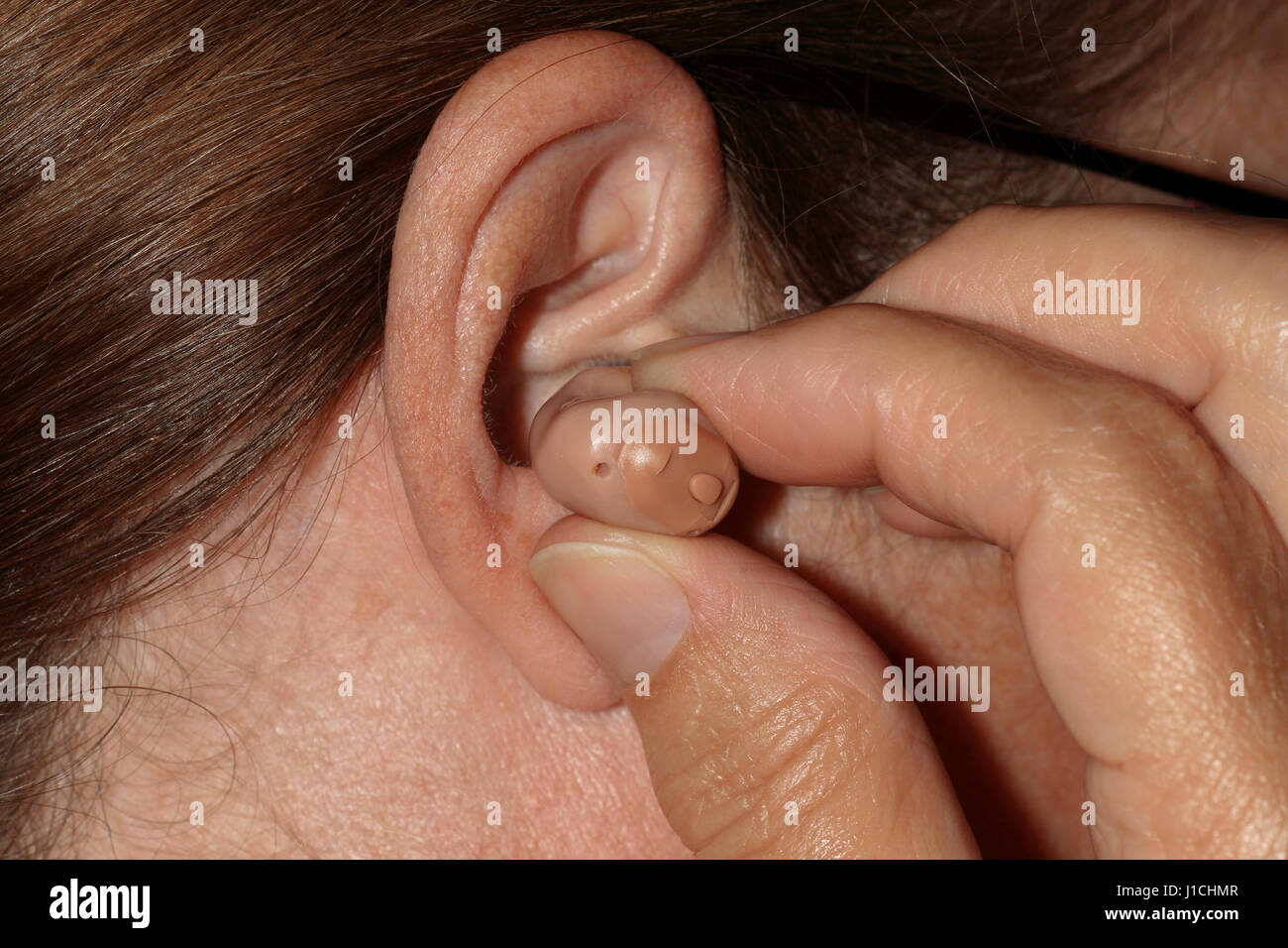Ear Insilating Inserting a hearing aid into the ear Stock Photo - Alamy