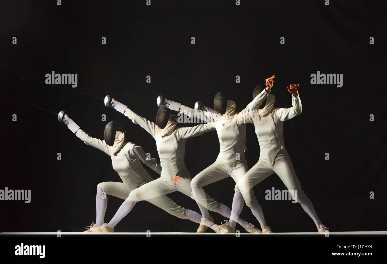 Fulllength portrait of woman wearing white fencing costume on black