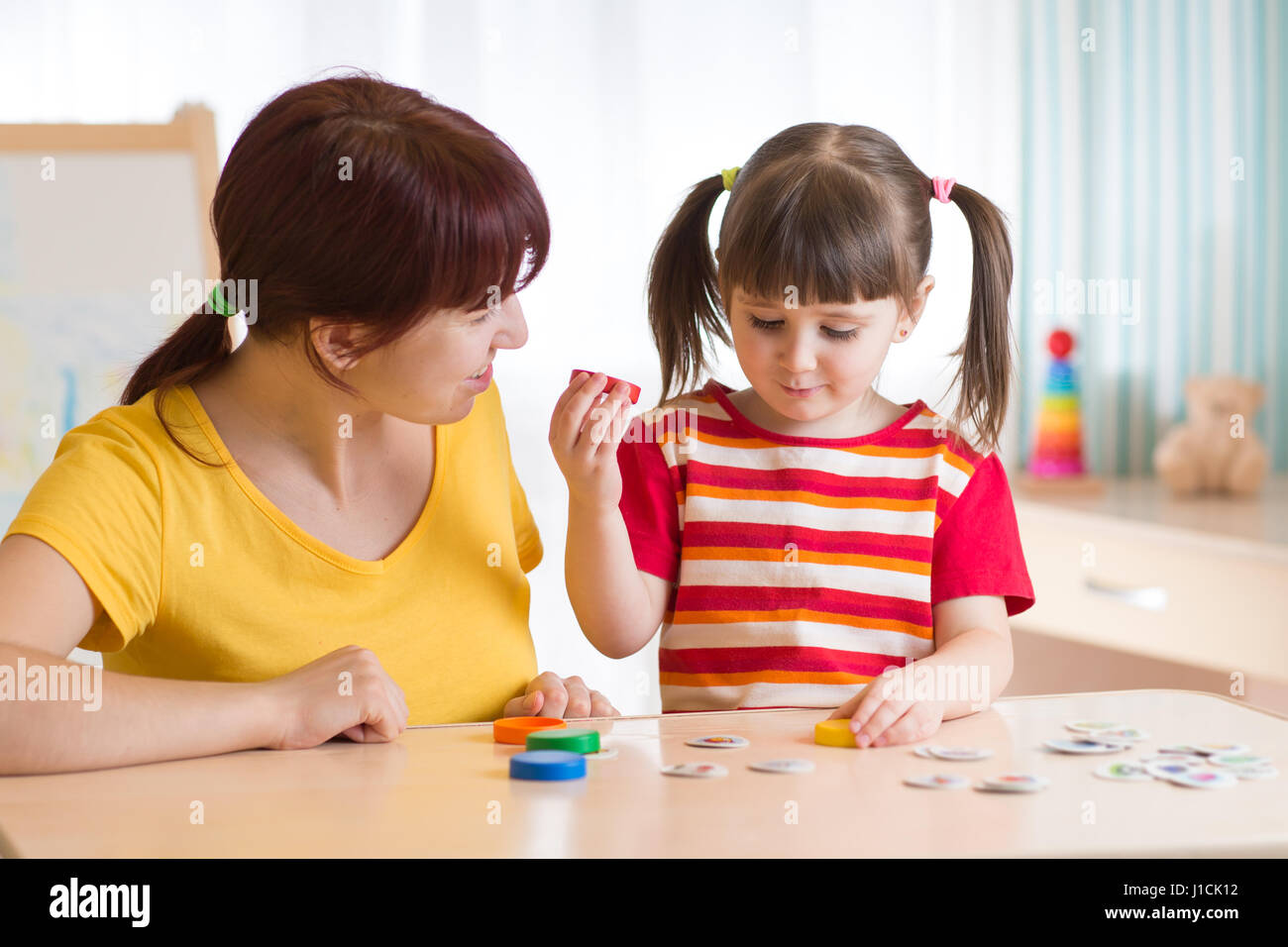 Kid playing with speech therapist Stock Photo