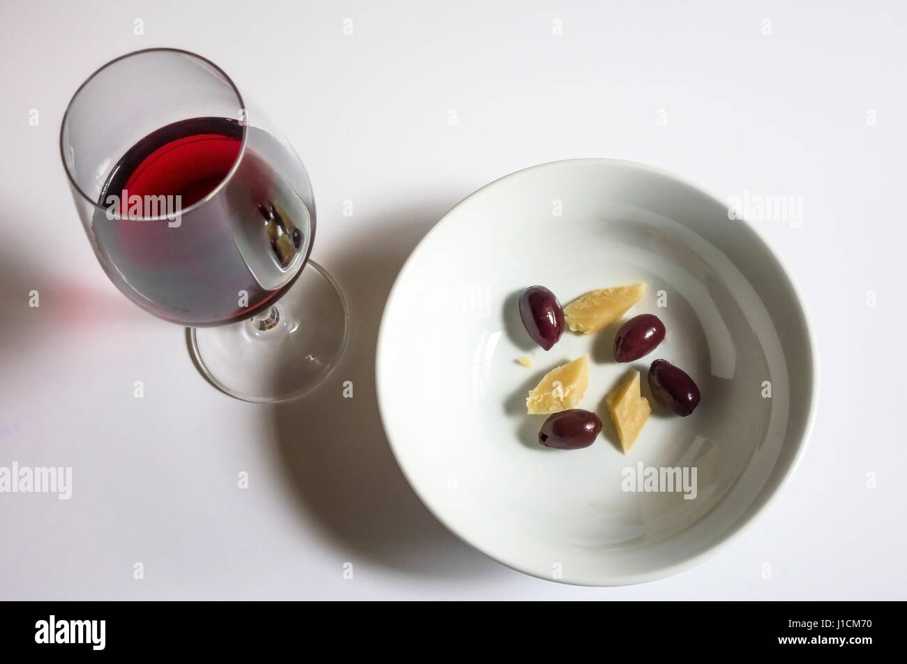 A snack of cheese and Kalamata olives with red wine Stock Photo