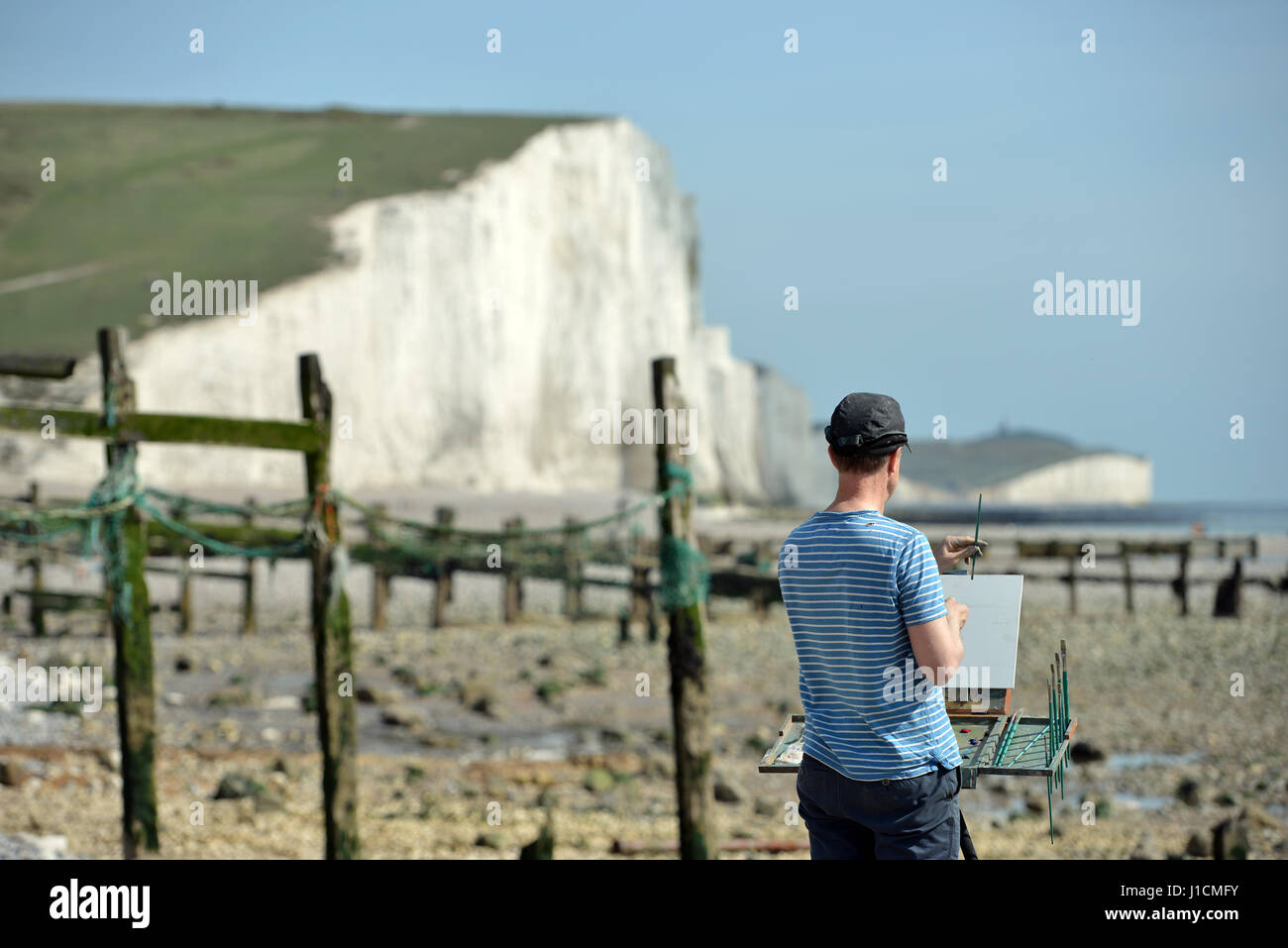 Artist painting the iconic Seven Sisters chalk cliffs in the South Downs national park, East Sussex Stock Photo