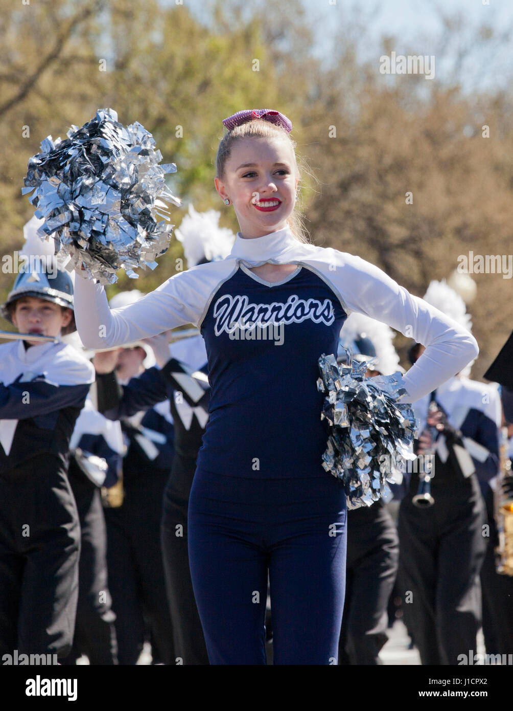 Caucasian female high school cheerleader participating in a street parade - USA Stock Photo