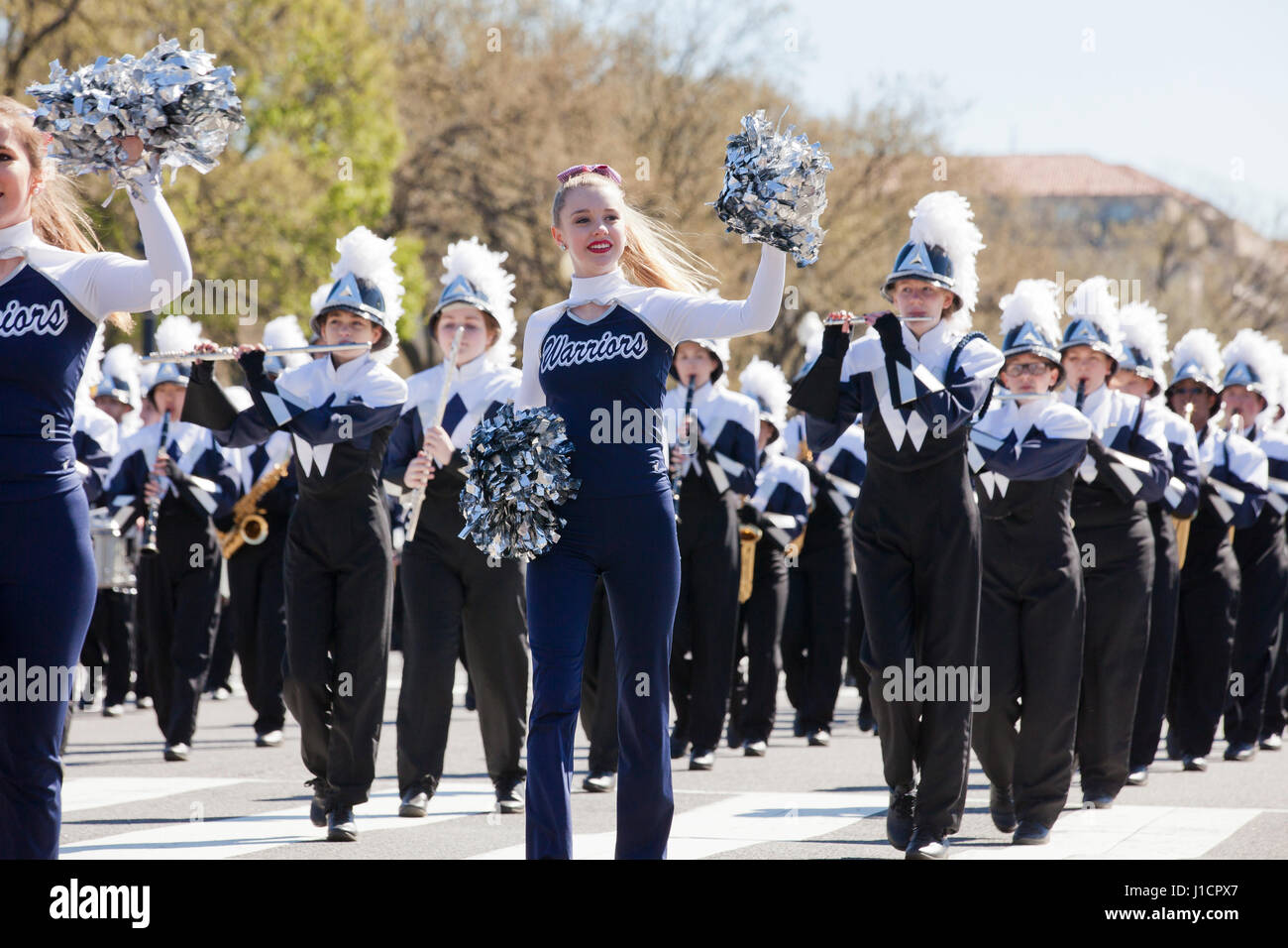Caucasian female high school cheerleader participating in a street parade - USA Stock Photo