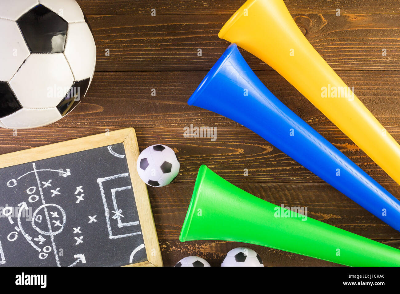 Soccer ball and Vuvuzela stadium horns on a wood background Stock Photo