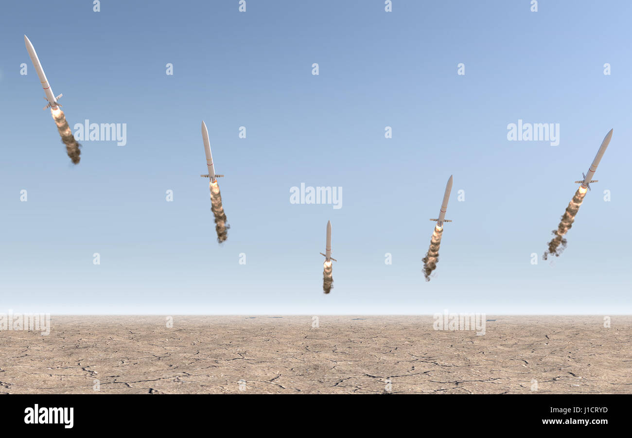 A row of intercontinental ballistic missiles launching in a desert on a blue sky backgrund - 3D render Stock Photo