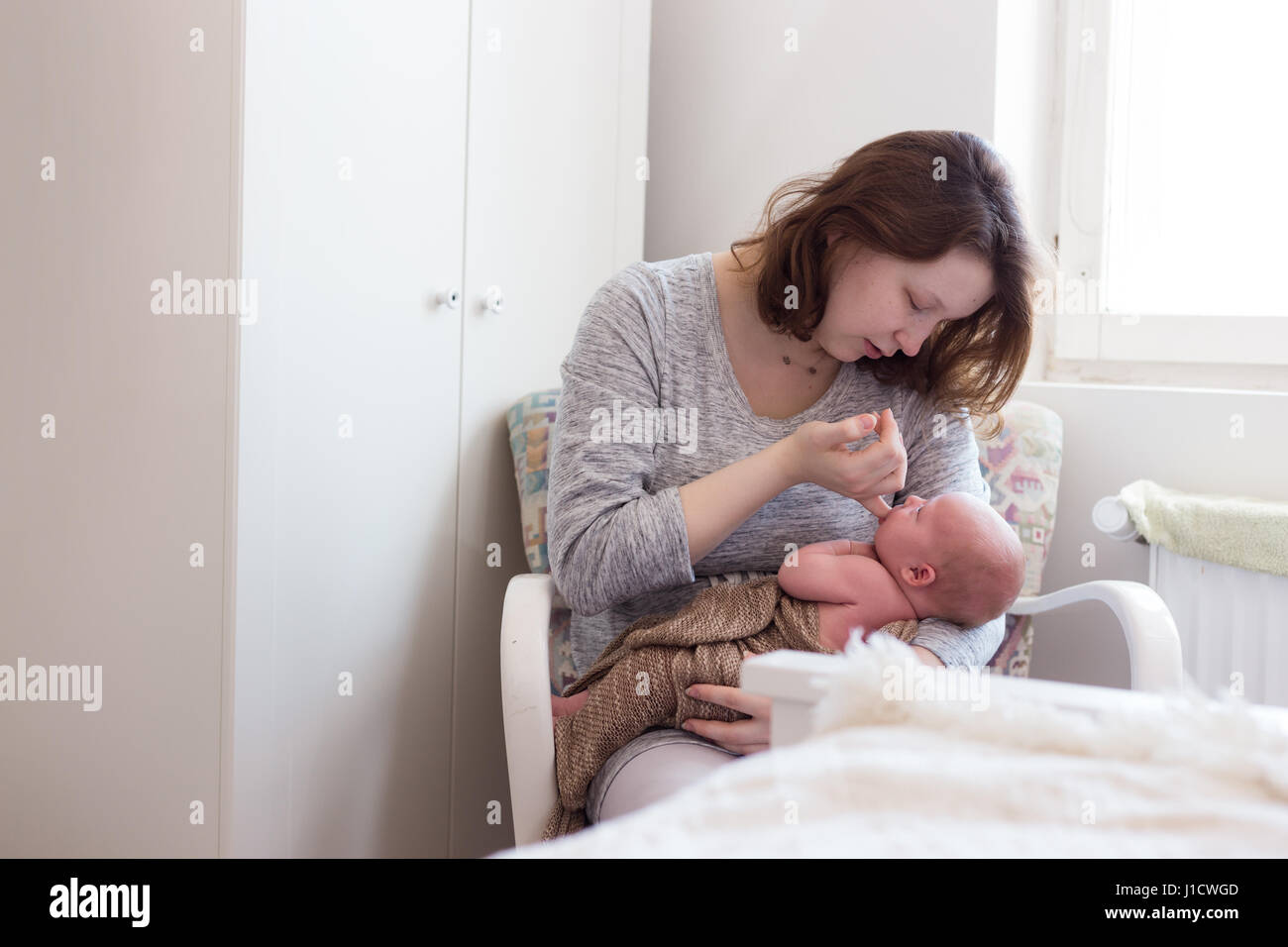 Young mother feeding her newborn daughter Stock Photo - Alamy