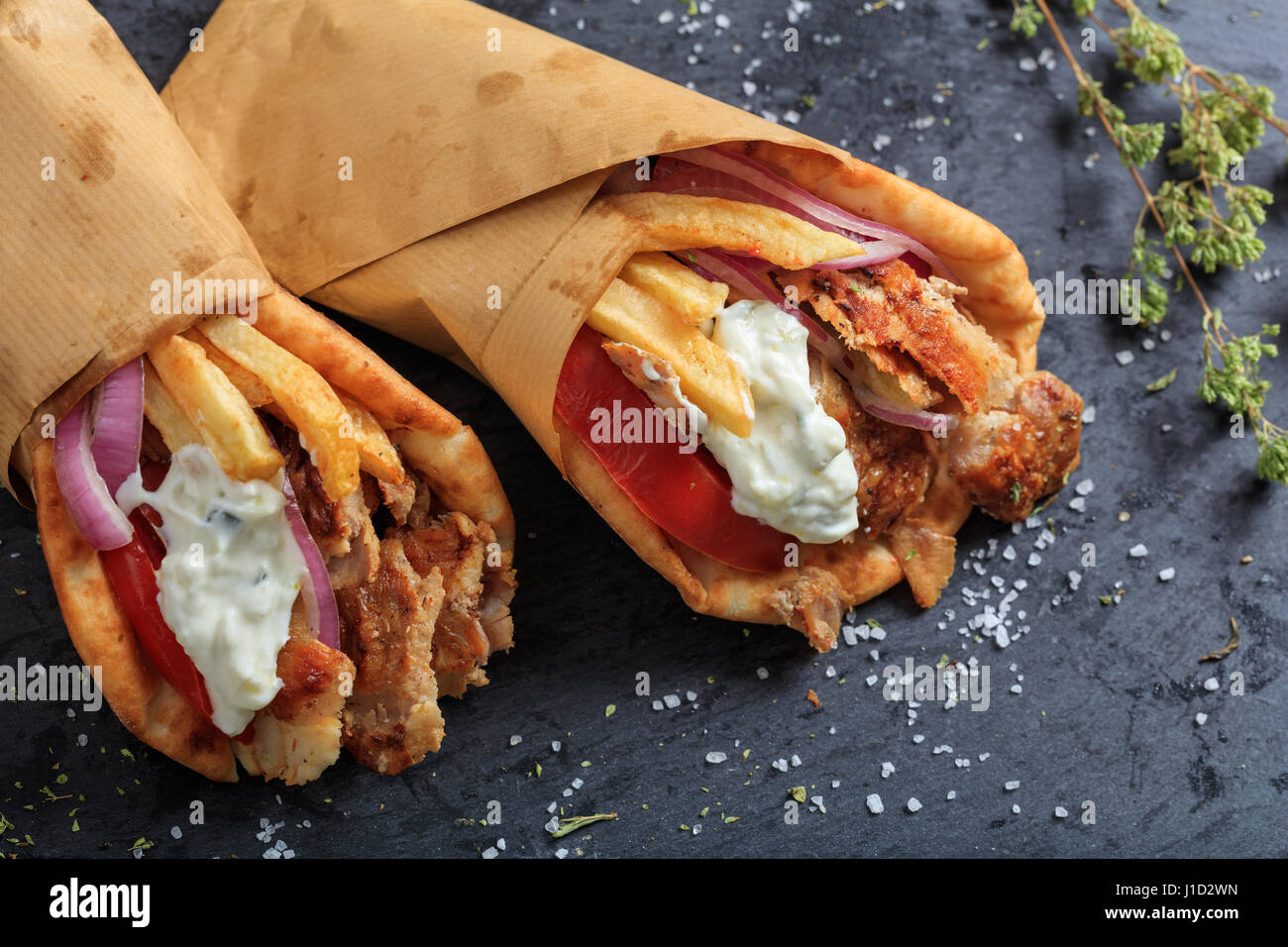 Greek gyros wrapped in pita breads on a black plate Stock Photo Alamy