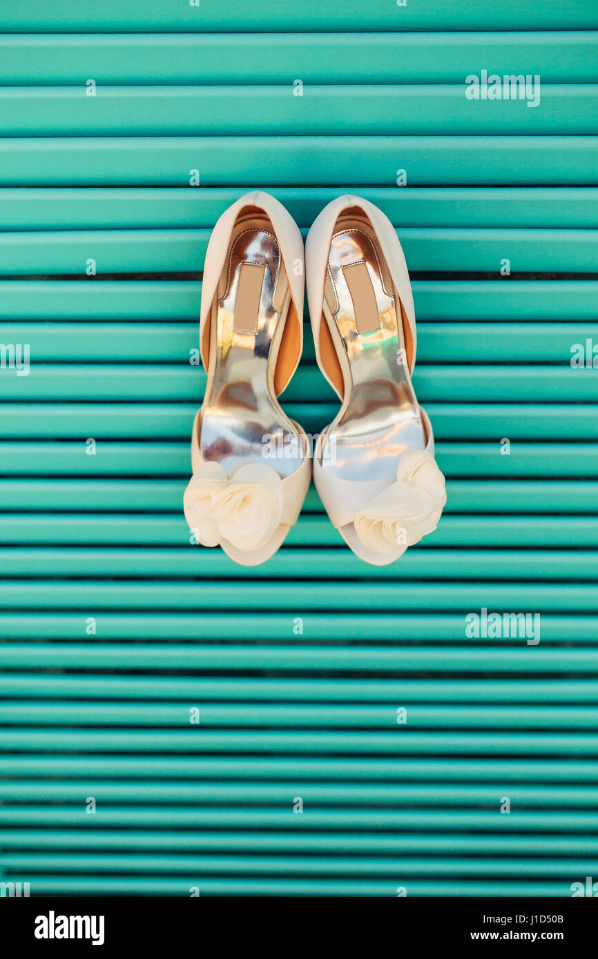 Wedding shoes of the bride on a blue wooden background Stock Photo - Alamy