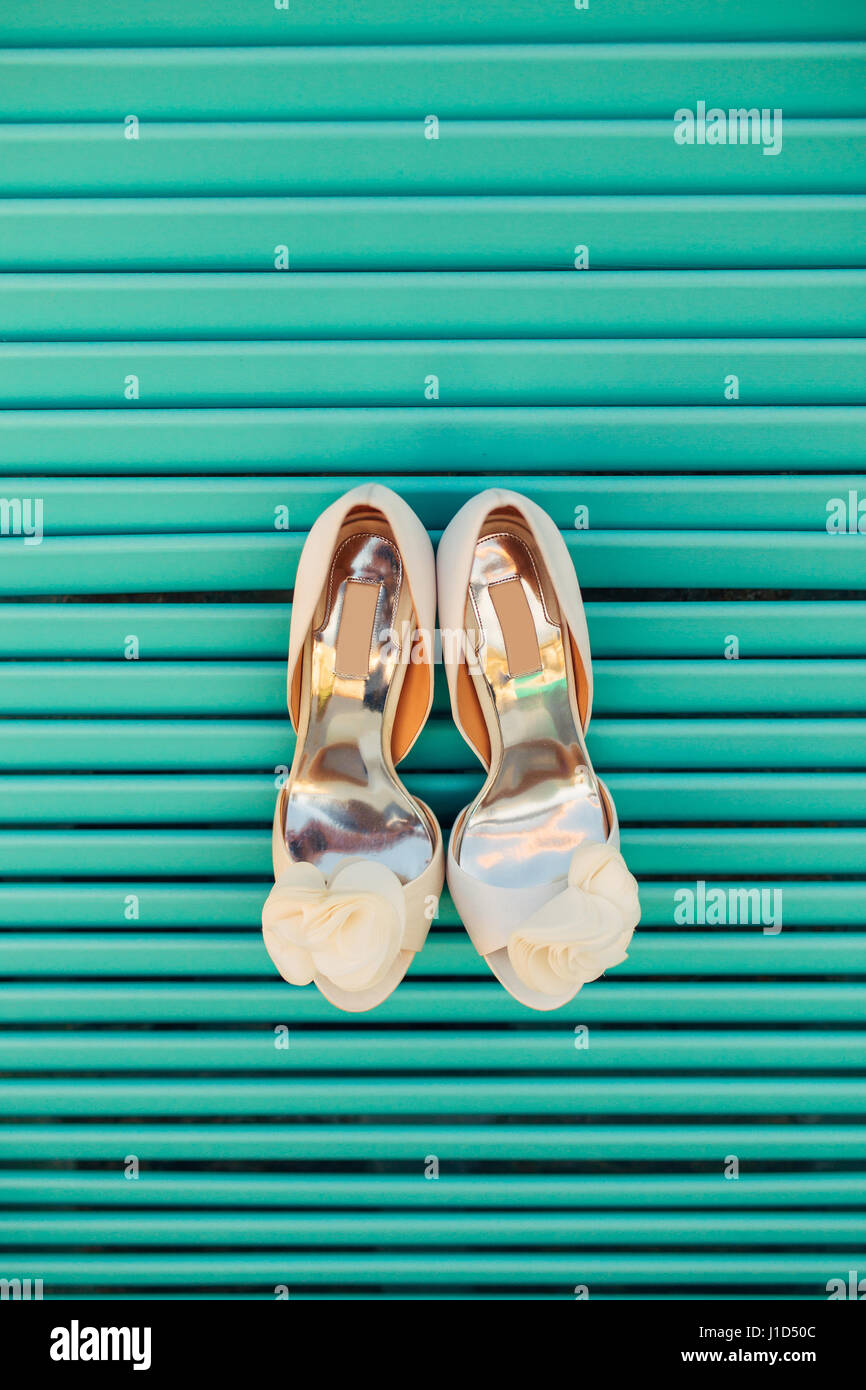 Wedding shoes of the bride on a blue wooden background Stock Photo - Alamy