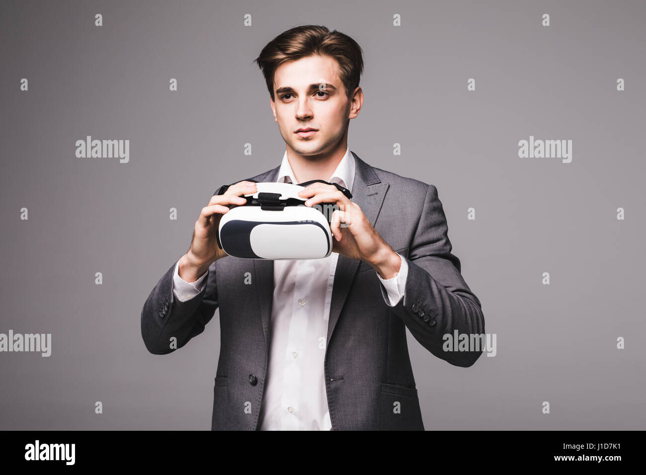 Man wearing virtual reality goggles gray background Stock Photo - Alamy