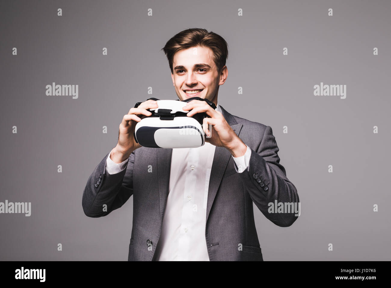 Man wearing virtual reality goggles gray background Stock Photo - Alamy