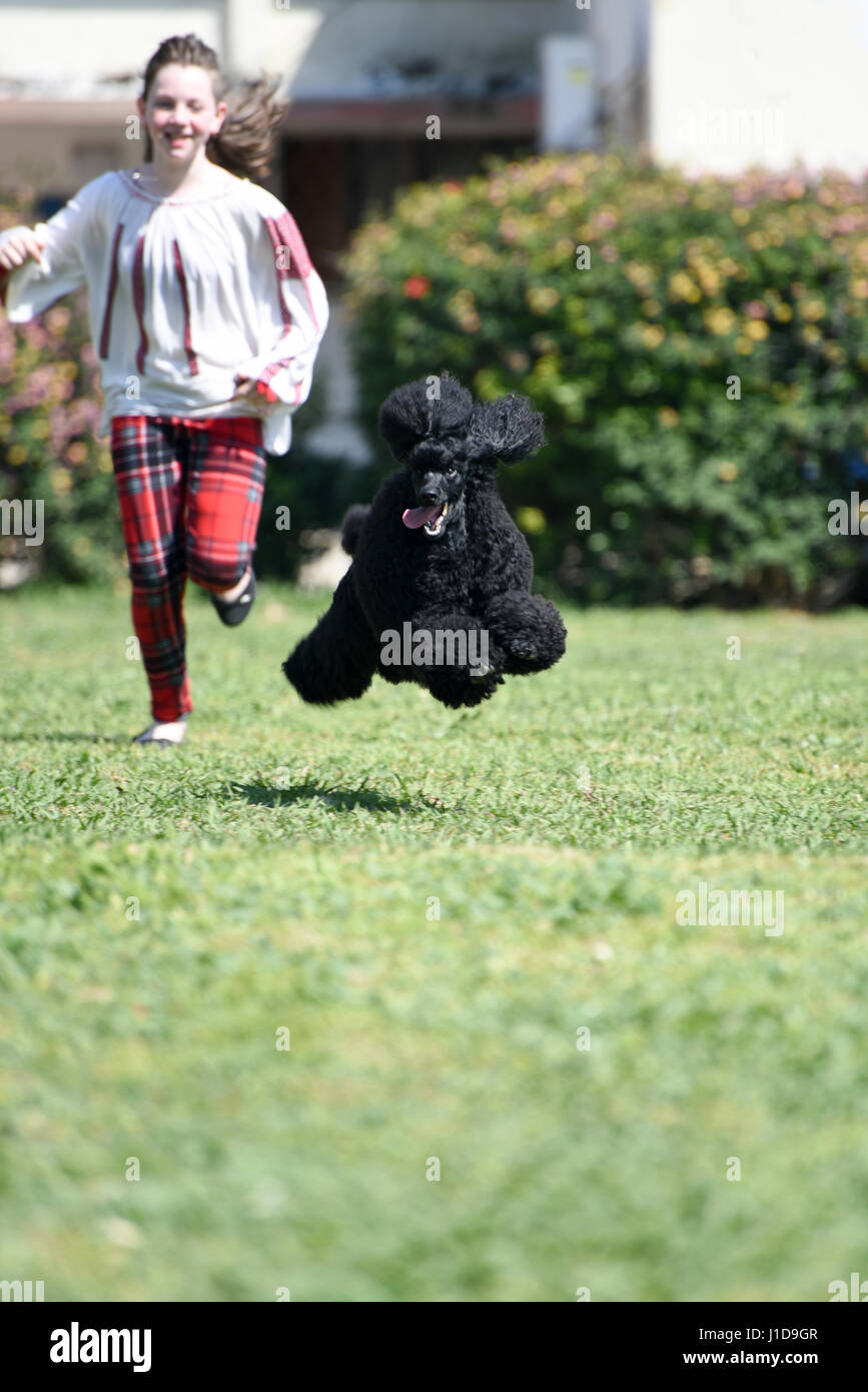 Girl runs and plays with her dog in a garden Stock Photo