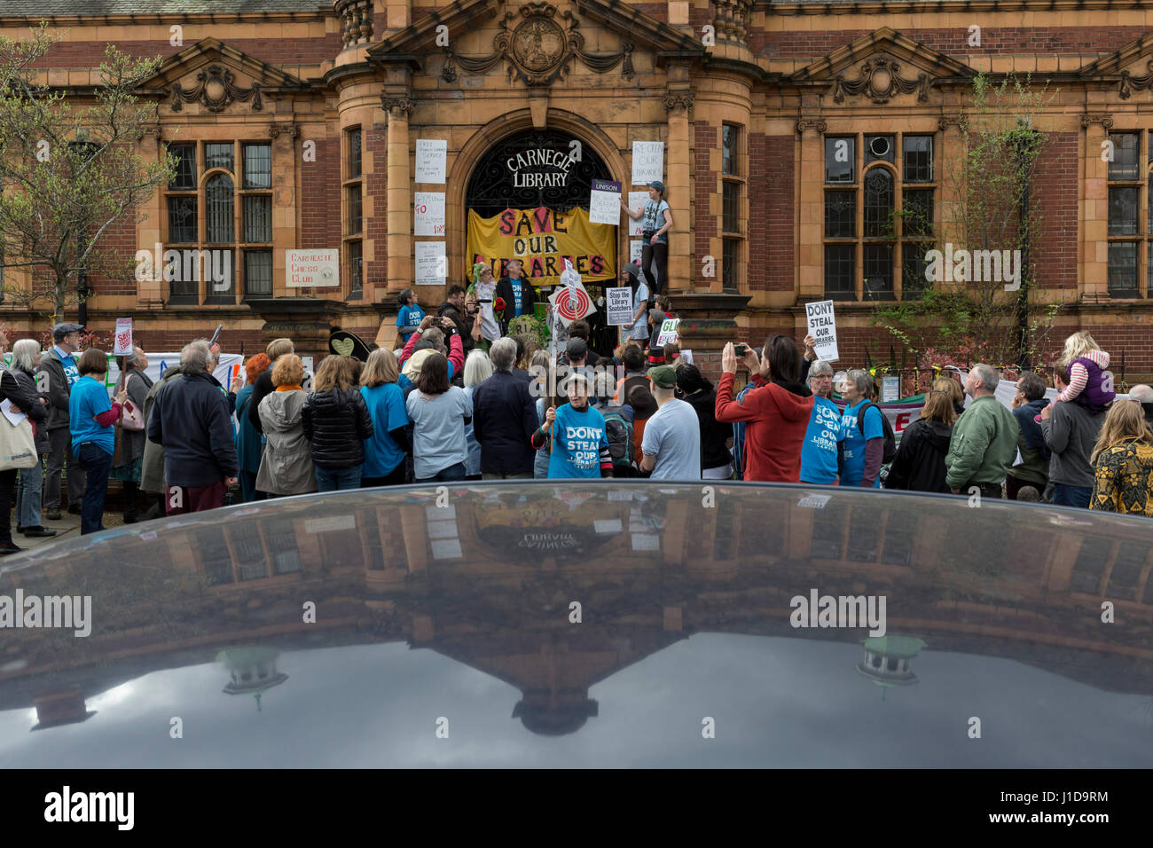 Angry protesters gather on the steps of the closed carnegie Library by Lambeth Council in Herne Hill in south London, Stock Photo