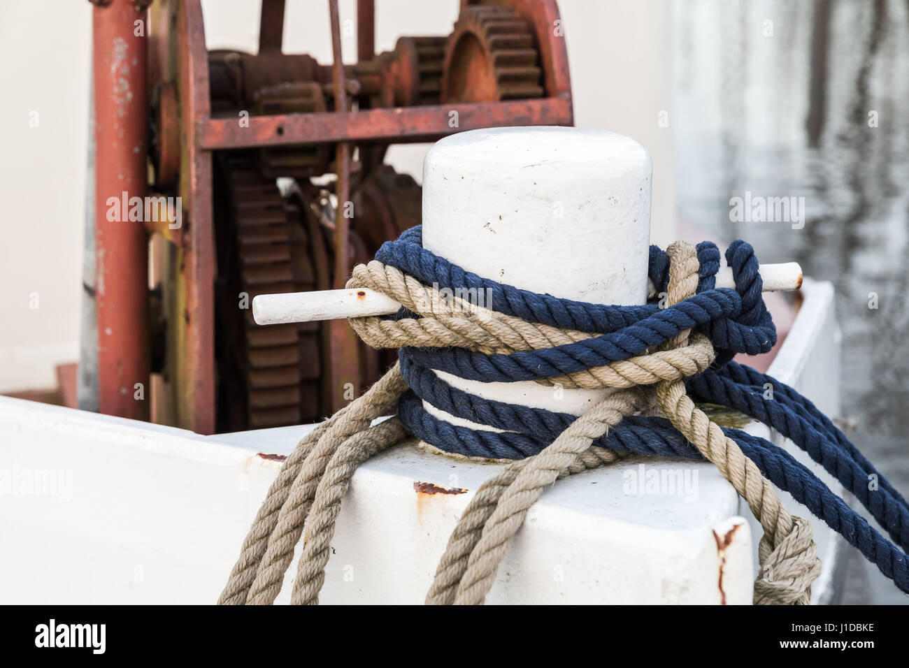 White bow bollard with ropes mounted on old ship deck Stock Photo