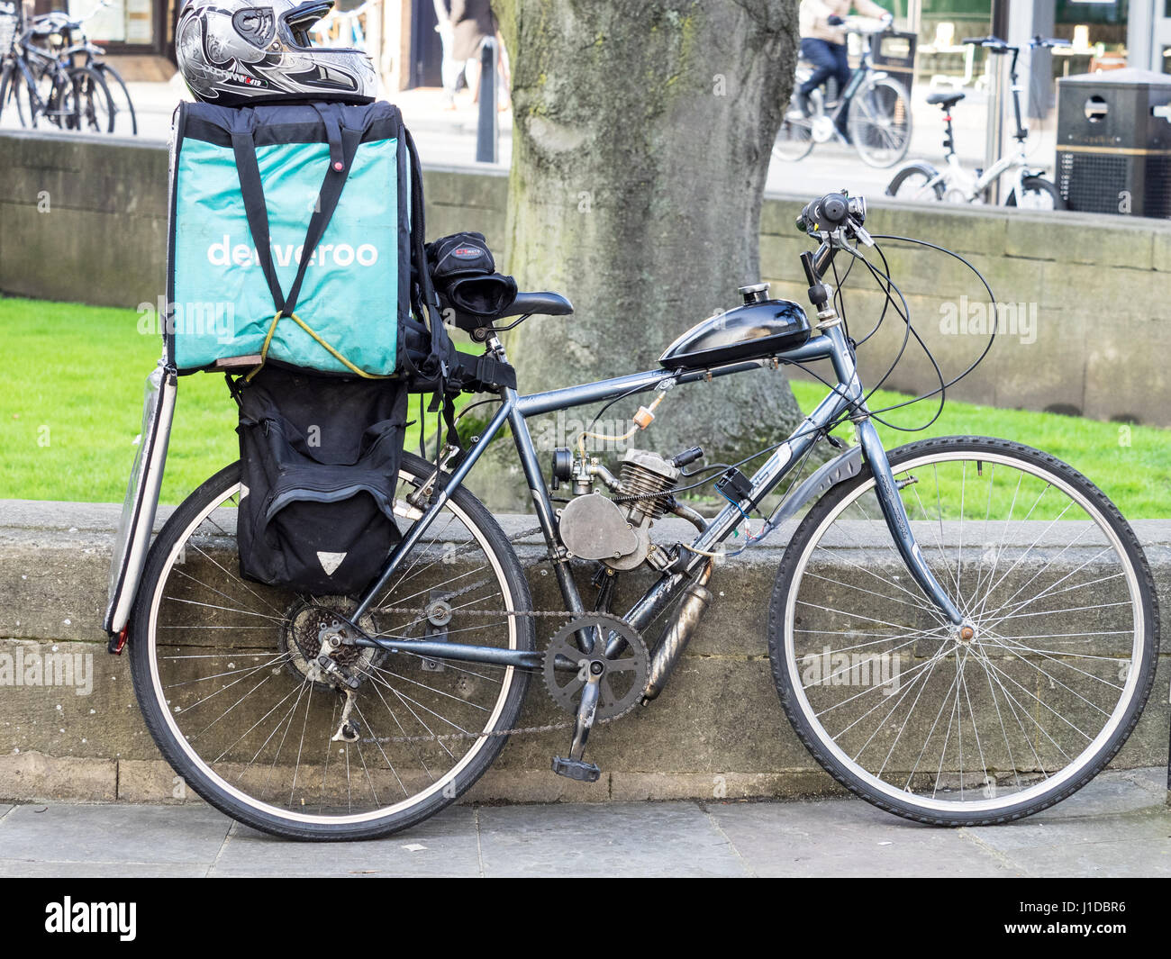 A Deliveroo delivery rider's bike, modified with the attachment of a small petrol engine. Stock Photo