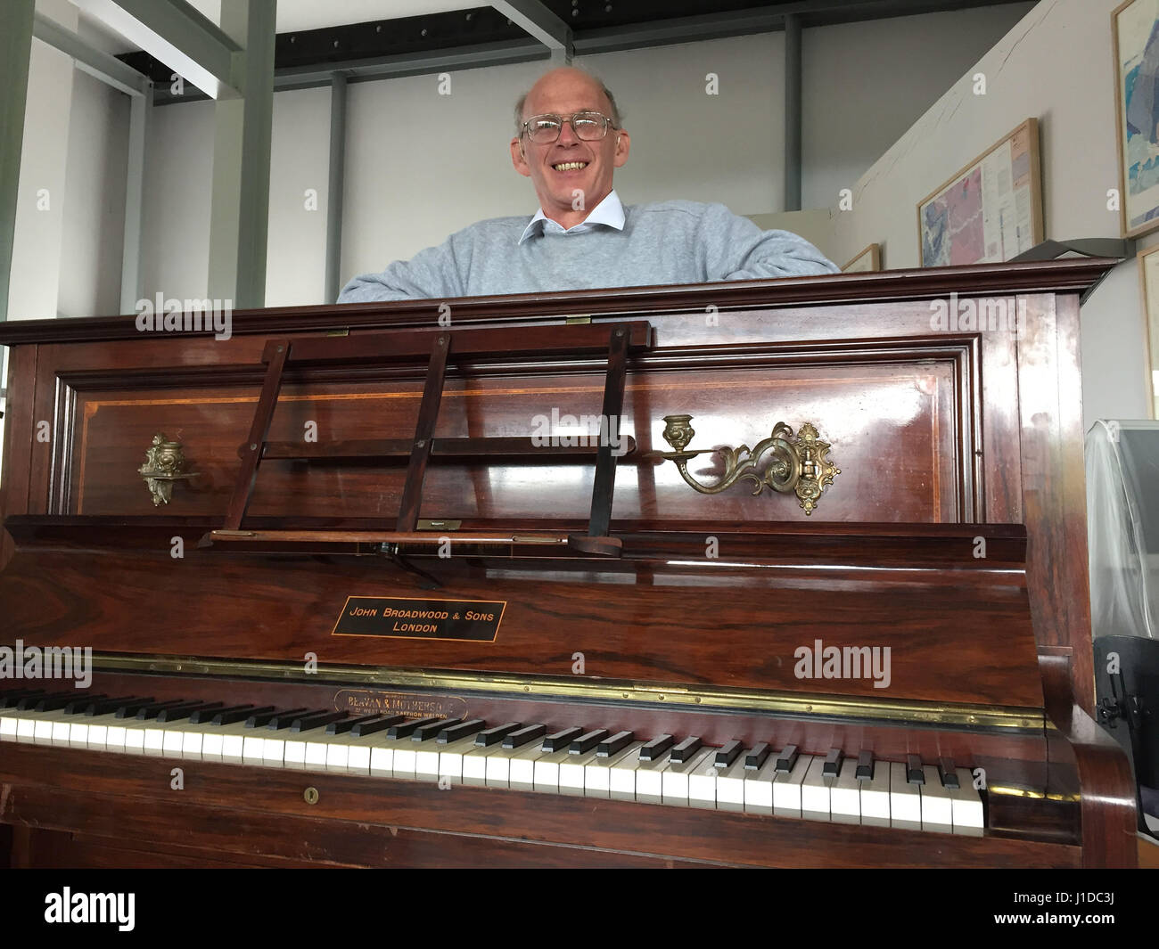 Tuner Martin Backhouse at Ludlow Museum with the piano where he found a stash of gold, as a mystery surrounds the identity of the rightful heirs to a treasure trove of gold coins worth enough to buy a house which were found hidden under an old piano's keyboard. Stock Photo