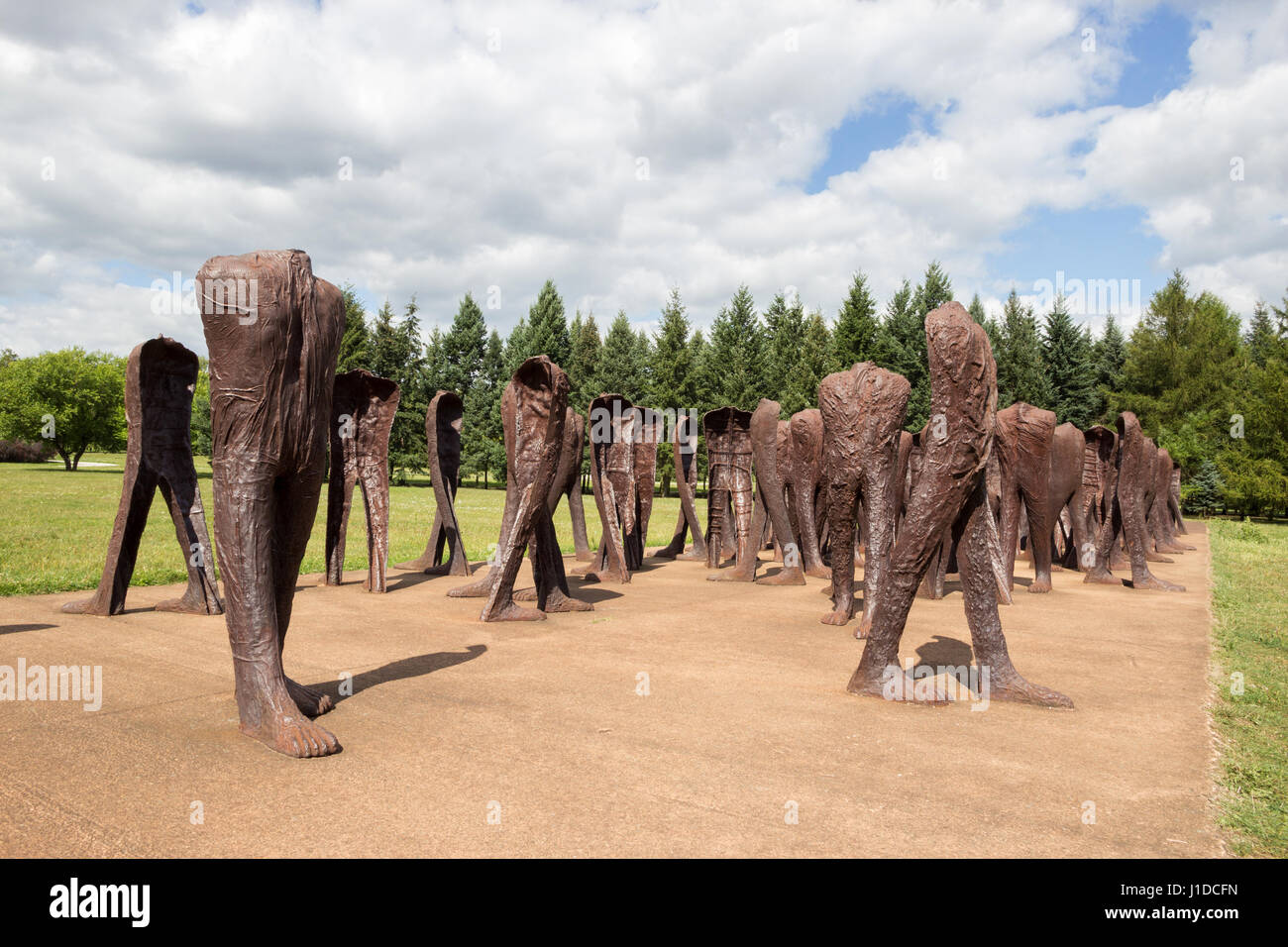 POZNAN, POLAND - AUG 20, 2014: Iron 2 meter tall headless figures marching aimlessly across the Citadel Park in Poznan. The monument is called Unrecog Stock Photo