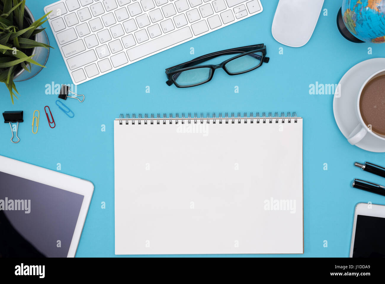 Modern blue office desk table with computer, tablet, cellphone, other