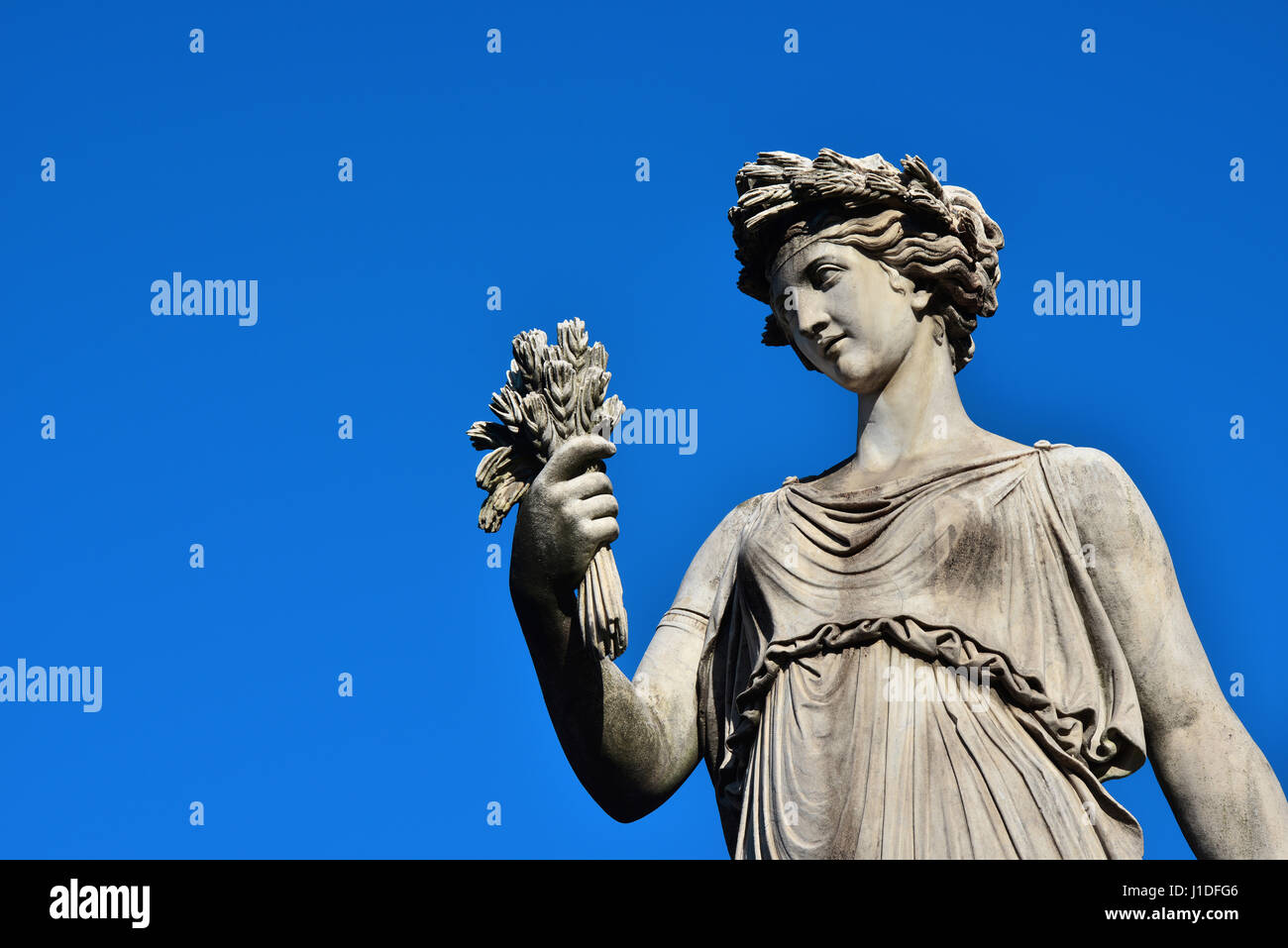 Ancient Roman or Greek neoclassical statue holding wheat in Rome (with copy space) Stock Photo