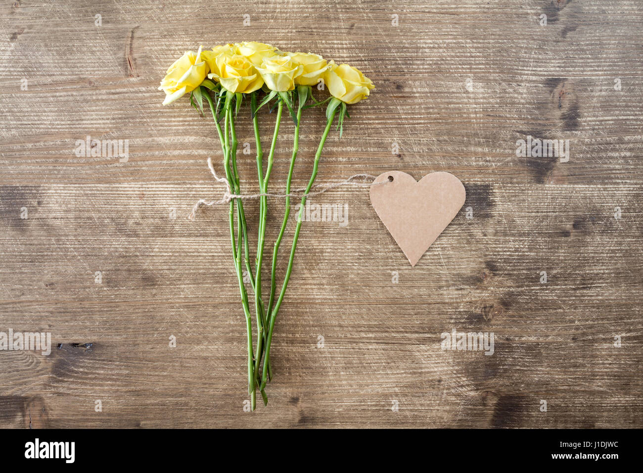 Bunch of yellow roses with heart shaped tag Stock Photo