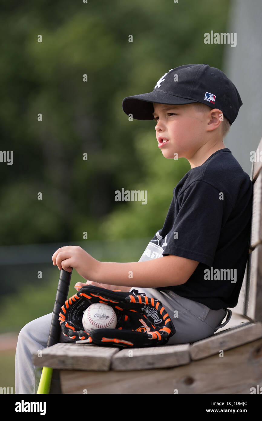 8 year old boy in baseball at field with baseball bat and mitt Stock -