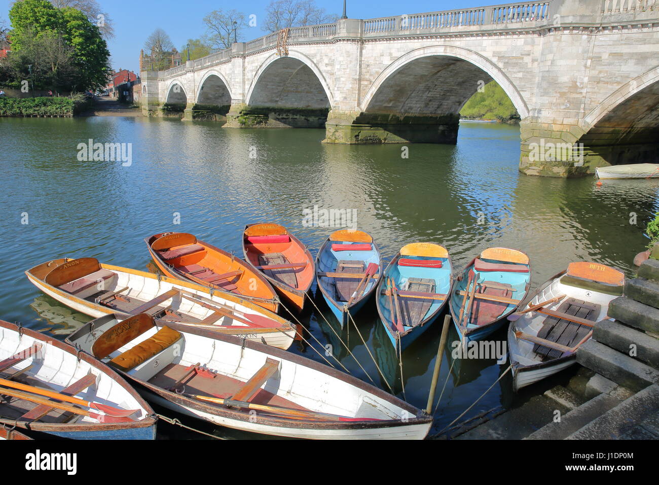 LONDON, UK - APRIL 9, 2017: Colorful boats on the river Thames in Richmond (Southwest London) with Richmond Bridge in the background Stock Photo