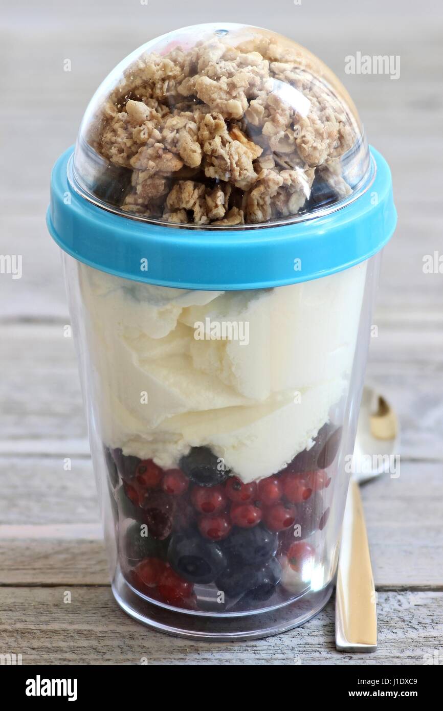 yogurt with fresh garden berries and cereals in reusable picnic